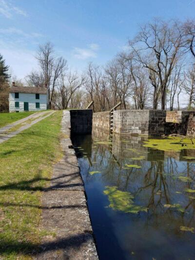 A house is reflected in the water of a canal.