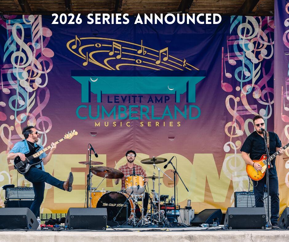 Three-piece band performing on colorful festival stage